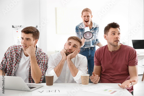 Φωτογραφία Angry boss with megaphone screaming at employees in office