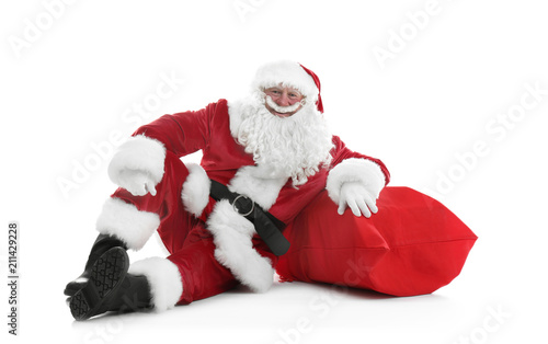 Authentic Santa Claus with big red bag full of gifts sitting on white background © New Africa
