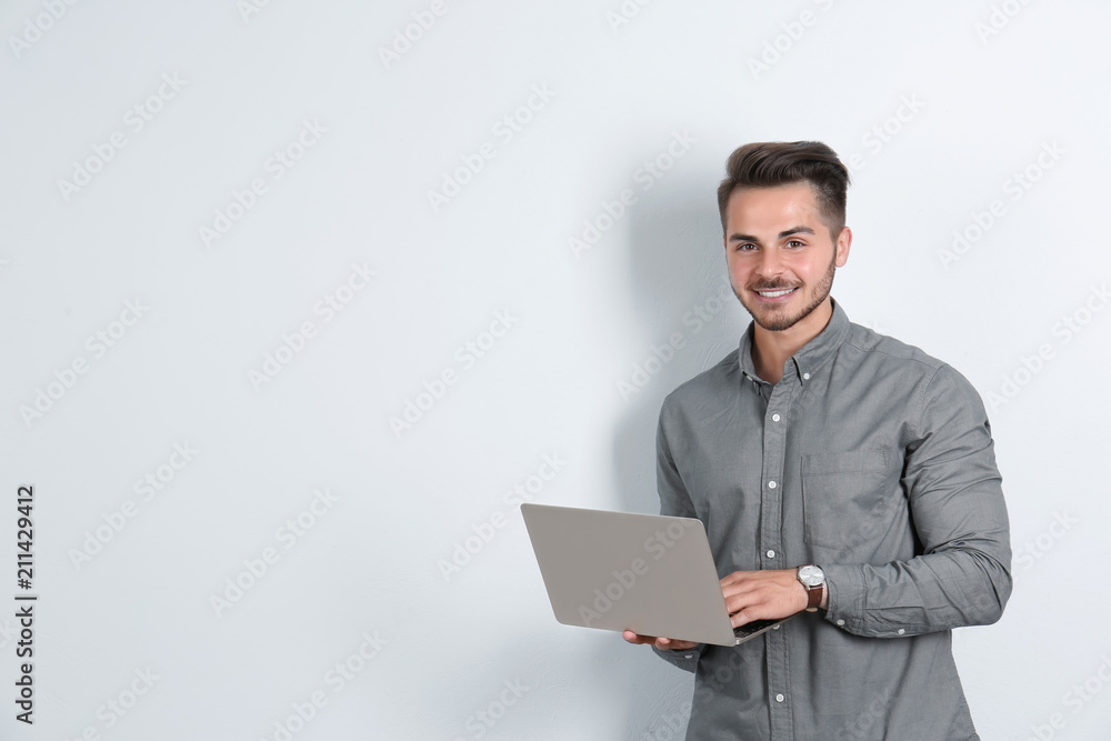 Man in casual clothes with laptop on light background Man in casual clothes with laptop on light background