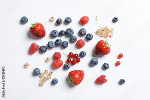 Raspberries and different berries on white background