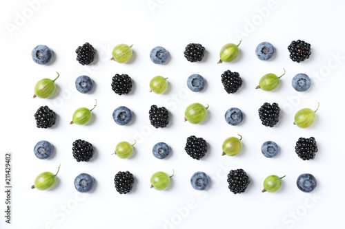 Composition with gooseberries, blackberries and blueberries on white background