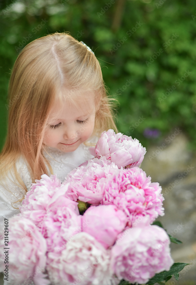 Portrait of a little girl smelling peonies Portrait of a little girl smelling peonies