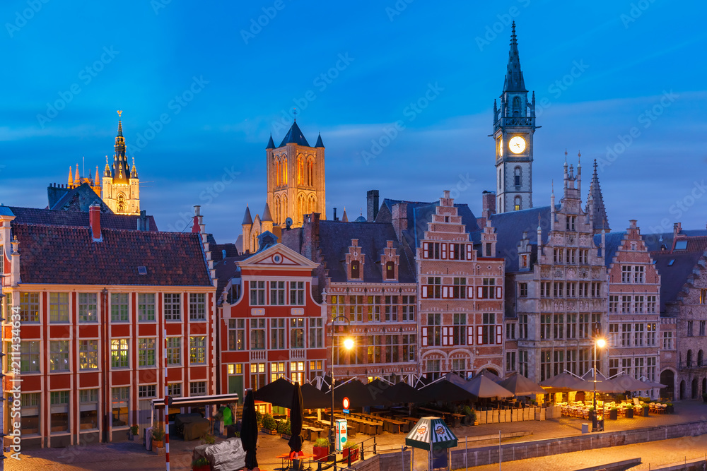 Aerial view of picturesque medieval buildings on the quay Graslei and towers of Old Town during morning blue hour, Ghent, Belgium