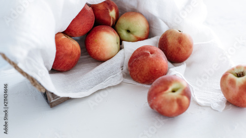 Peaches in basket on white linen