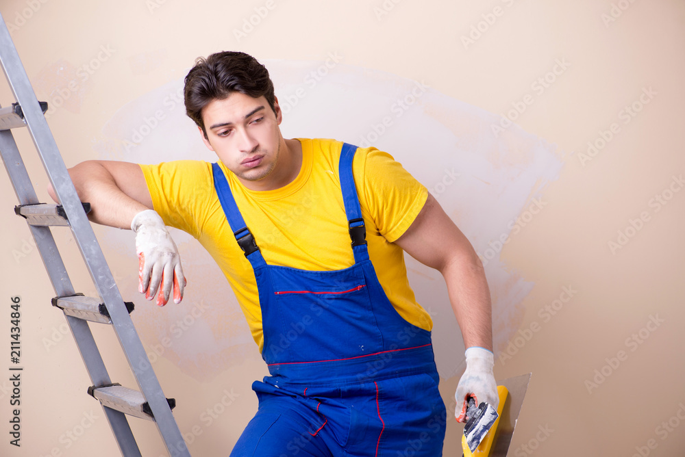 Young contractor employee applying plaster on wall
