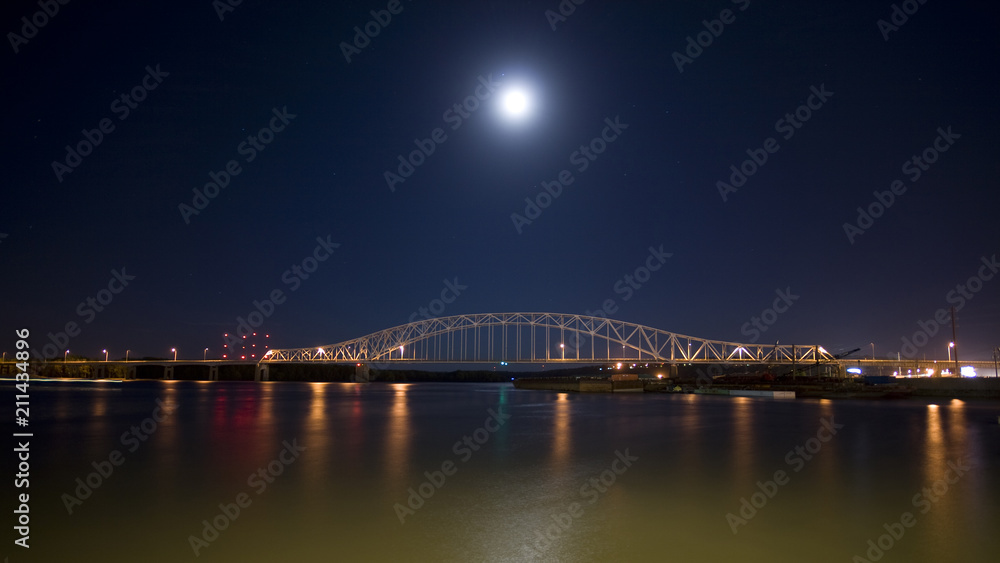 Bridge at night over the mighty Mississippi river barges