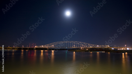 Bridge at night over the mighty Mississippi river barges