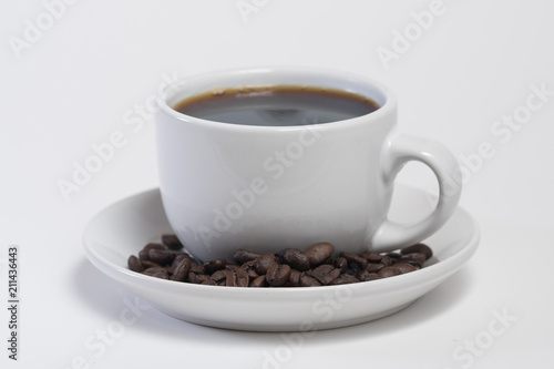 Coffee cup filled with hot fresh coffee with a drip of coffee being poured in