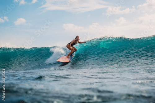Professional surf girl on surfboard. Woman in ocean during surfing. Surfer and ocean wave