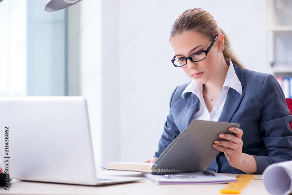 Businesswoman working at her desk in office Businesswoman working at her desk in office