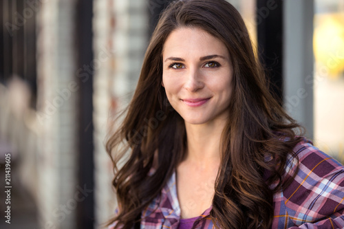 Beautiful casual natural brunette commercial model portrait close up headshot with dimpled grin