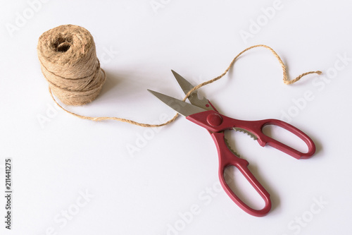 Kitchen scissors with a spool of cord on a white background.