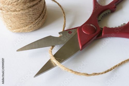 Kitchen scissors with a spool of cord on a white background.