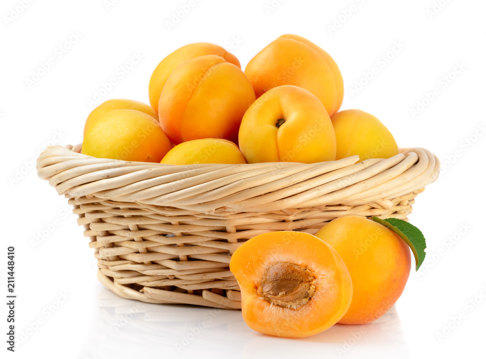 Fresh apricots in the basket are isolated on a white background.