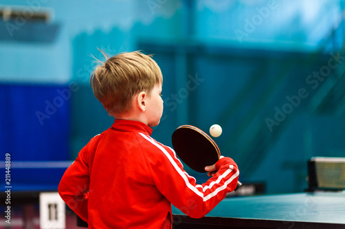 a child plays table tennis in the gym