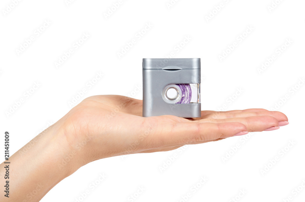 Dental floss in grey container with hand isolated on white background. Dental floss in grey container with hand isolated on white background.