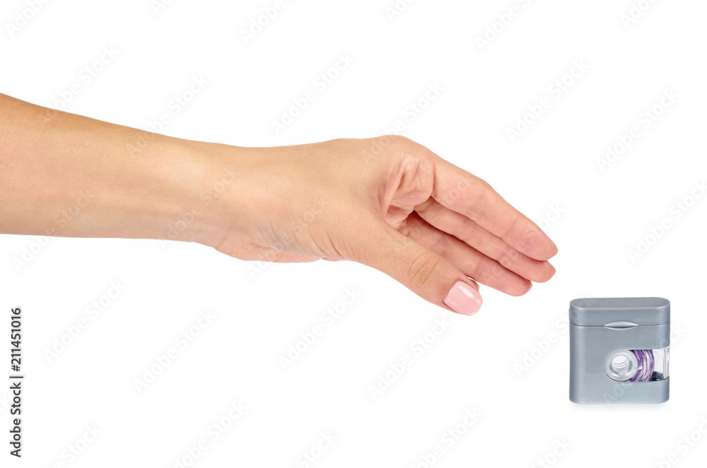 Dental floss in grey container with hand isolated on white background. Dental floss in grey container with hand isolated on white background.