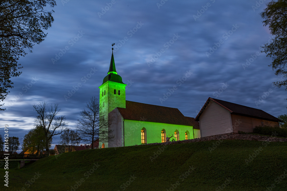 Beautiful bright green artificial light over church in Viljandi, Estonia.