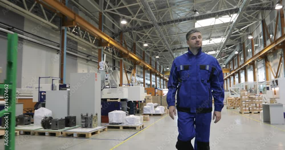 Engineer in in blue uniform is Walking Through Factory. front View Engineer in in blue uniform is Walking Through Factory. front View