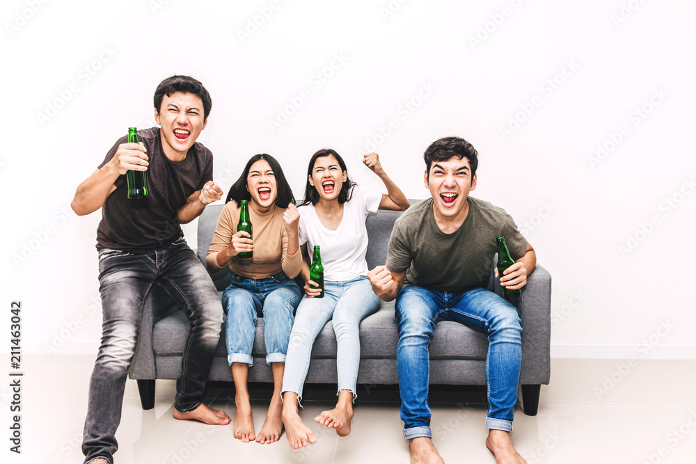 Group of friends drinking beer together and watching soccer game on sofa at home.Friendship and party concept Group of friends drinking beer together and watching soccer game on sofa at home.Friendship and party concept