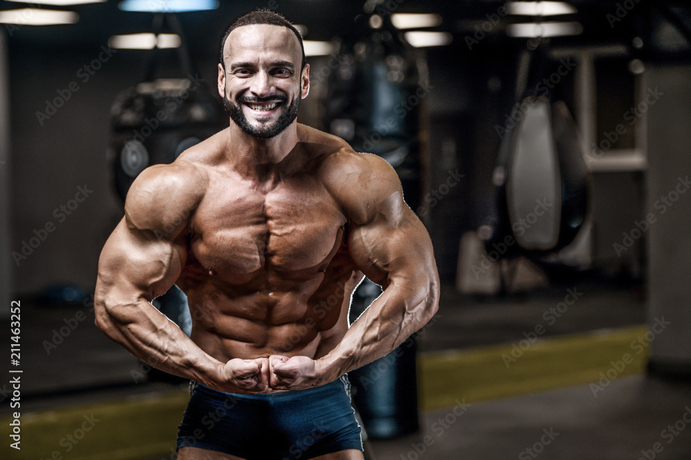 Brutal strong bodybuilder athletic men pumping up muscles with dumbbells Brutal strong bodybuilder athletic men pumping up muscles with dumbbells