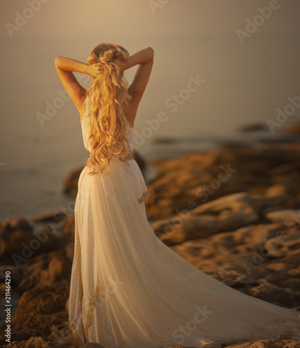 Obraz na płótnie Beautiful girl in a long white wedding dress in Greek style is the old Greek god