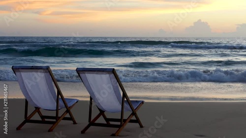 Two beach chairs on the beautiful sunset beach.