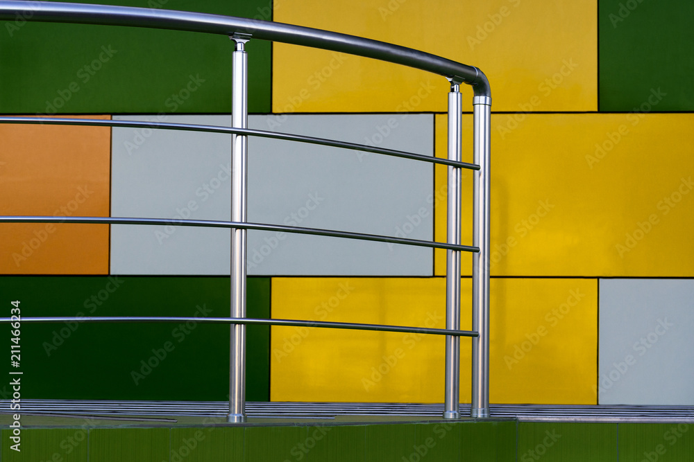 Steps and shoes from stainless steel on the background of a multi-colored fa ade of cubes