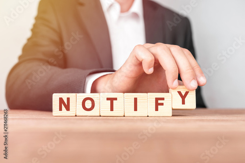 Man made word NOTIFY with wood blocks
