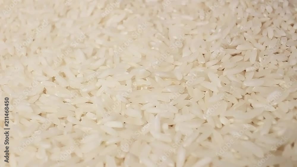 Raw rice grains rotating pattern macro texture background backdrop footage video. Raw rice grains rotating pattern macro texture background backdrop footage video.