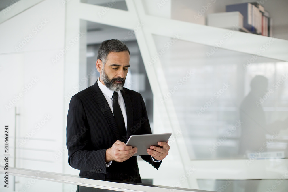 Middle age businessman with tablet in the office Middle age businessman with tablet in the office