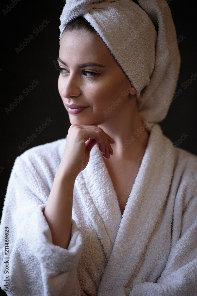 Obraz premium Young woman in a bathrobe and towel on her head, spa and care portrait, clean natural face