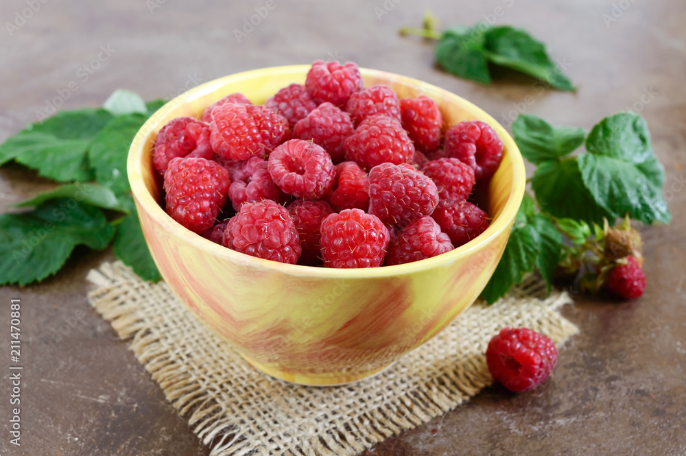Fresh ripe tasty raspberries in a yellow ceramic bowl. Summer berries. Fresh ripe tasty raspberries in a yellow ceramic bowl. Summer berries.