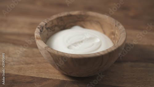 sour cream pour into wood bowl closeup
