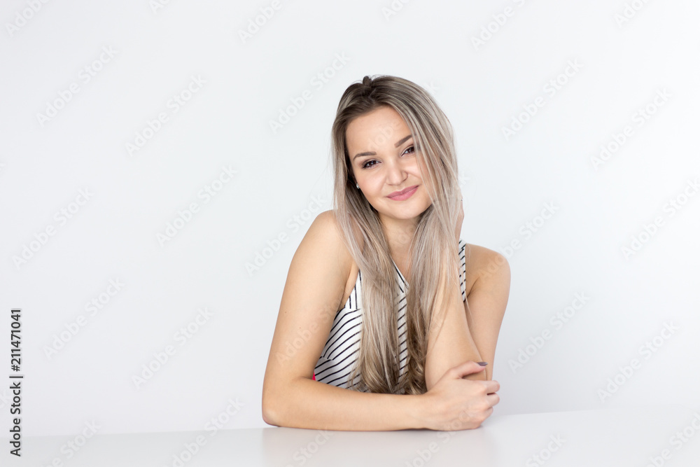 pretty young blonde woman, wearing light dress, smiling and looking at the camera pretty young blonde woman, wearing light dress, smiling and looking at the camera