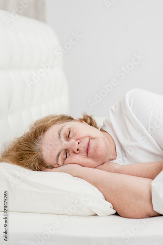 senior woman sleeping on bed at home. Space for text