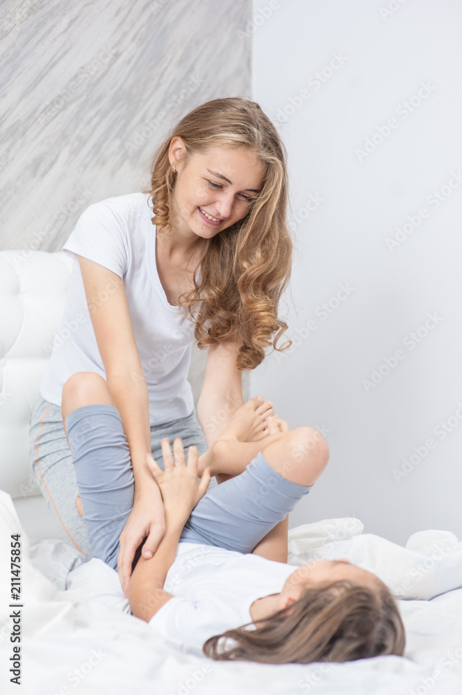 Happy mother and daughter have fun on the bed Happy mother and daughter have fun on the bed
