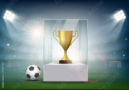 Soccer ball with the golden cup of championship at the stadium