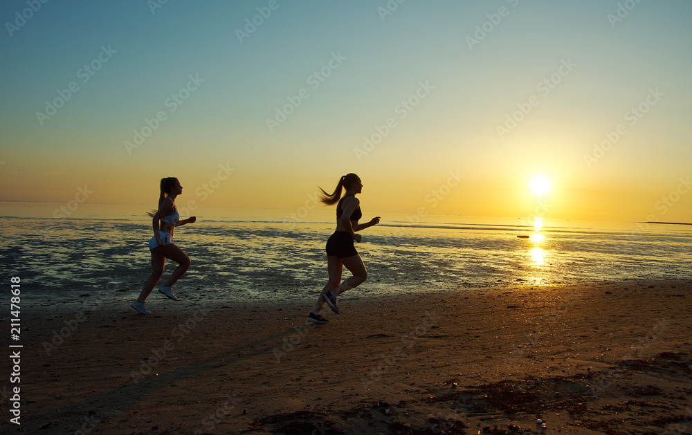 Fototapeta premium two girl running by the sea on the beach