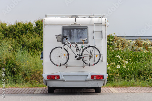 caravan with a bicycle in the parking lot