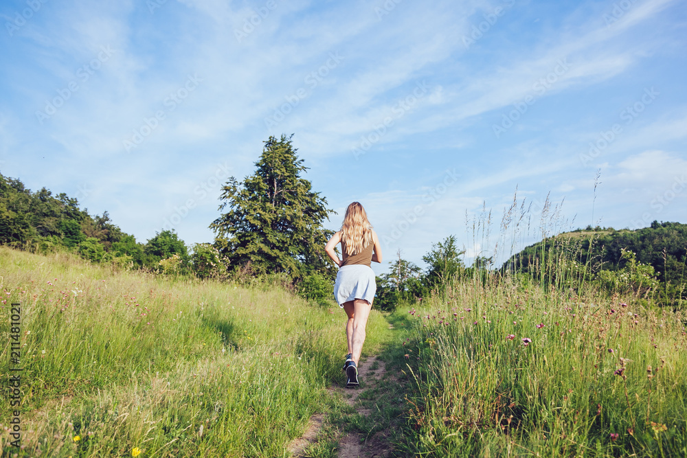 Young woman jogging in the nature at sunset Young woman jogging in the nature at sunset