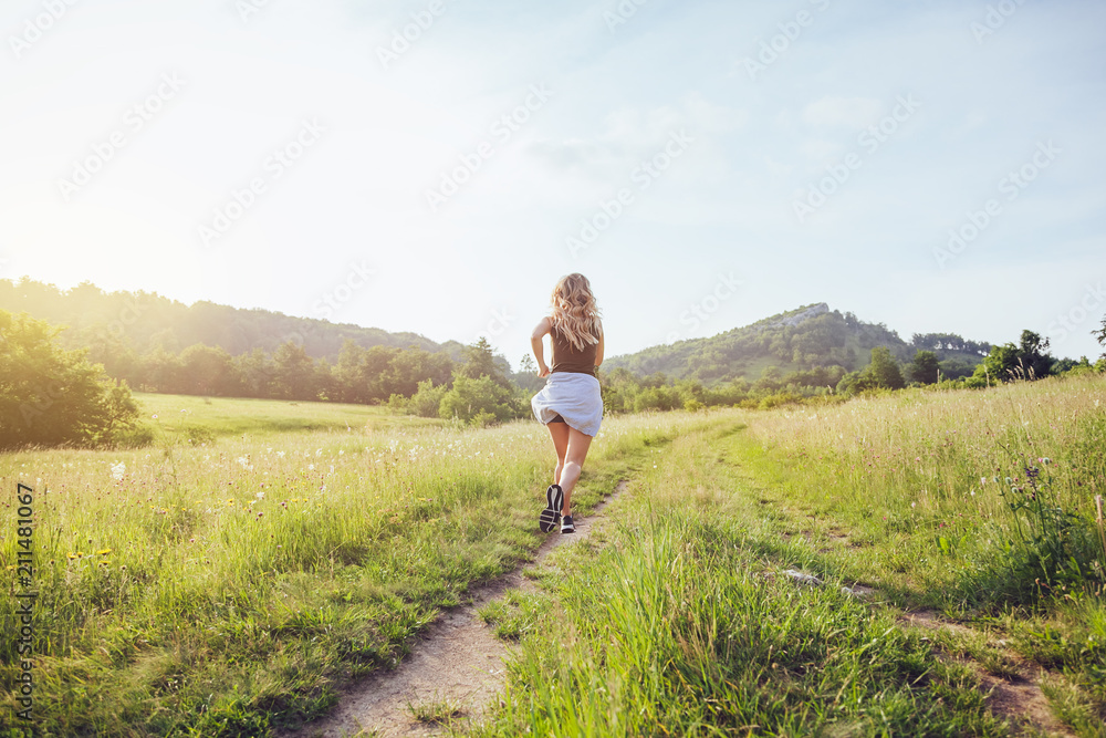 Young woman jogging in the nature at sunset