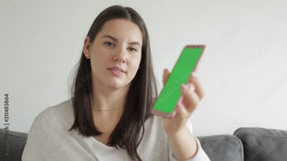 Beautiful young girl shows mobile phone. Green screen chroma key Beautiful young girl shows mobile phone. Green screen chroma key