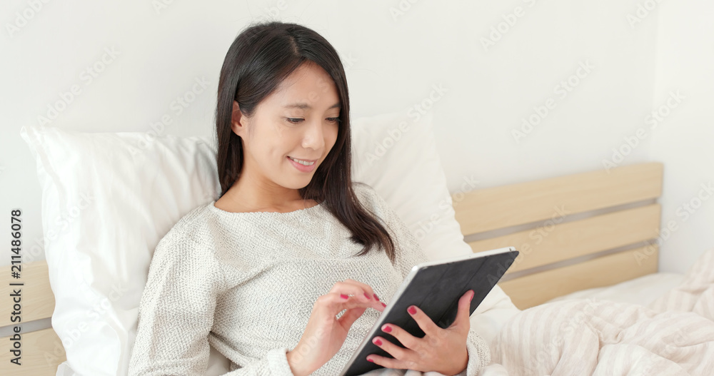 Woman work on tablet computer on bed Woman work on tablet computer on bed