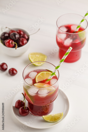 Wallpaper Mural Cherry juice with ice and lime in a glass beaker, light background. White background. Torontodigital.ca