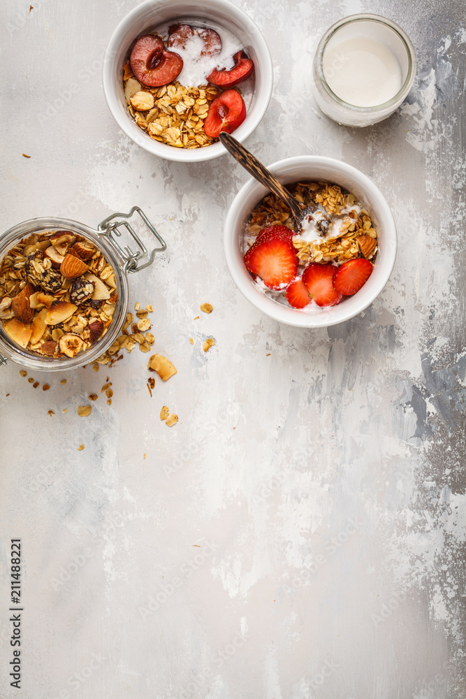 Homemade granola with yogurt and berries in small white bowls. Healthy food concept. Homemade granola with yogurt and berries in small white bowls. Healthy food concept.