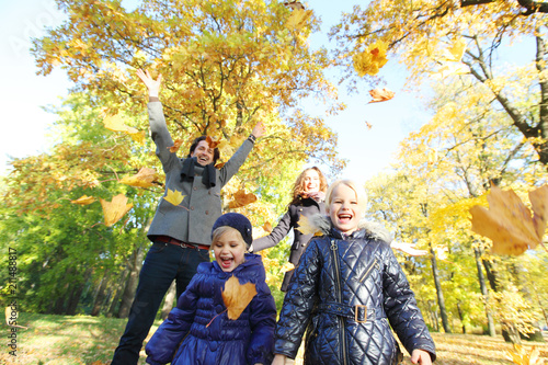 Happy family playing with autumn leaves