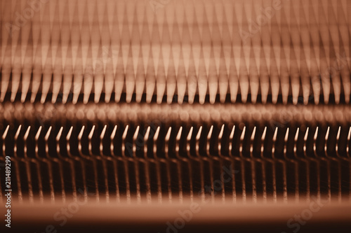 Detailed texture of engine water cooling radiator. Background image of orange automobile part with copy space close up.