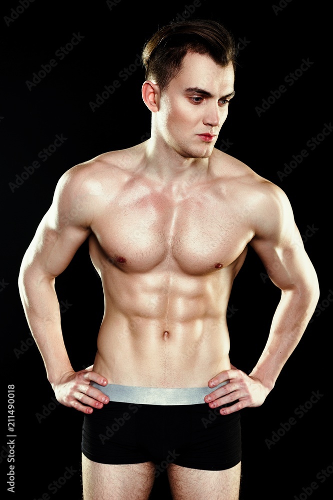 Fototapeta premium Handsome sporty young man in underwear posing on dark background