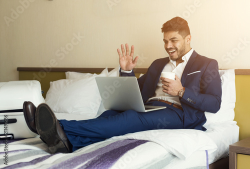 Businessman talking on laptop in hotel room © Prostock-studio